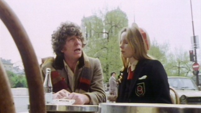 The Doctor and Romana have lunch at La Creme de Paris, with Notre Dame in the background, in City of Death (c) BBC Studios